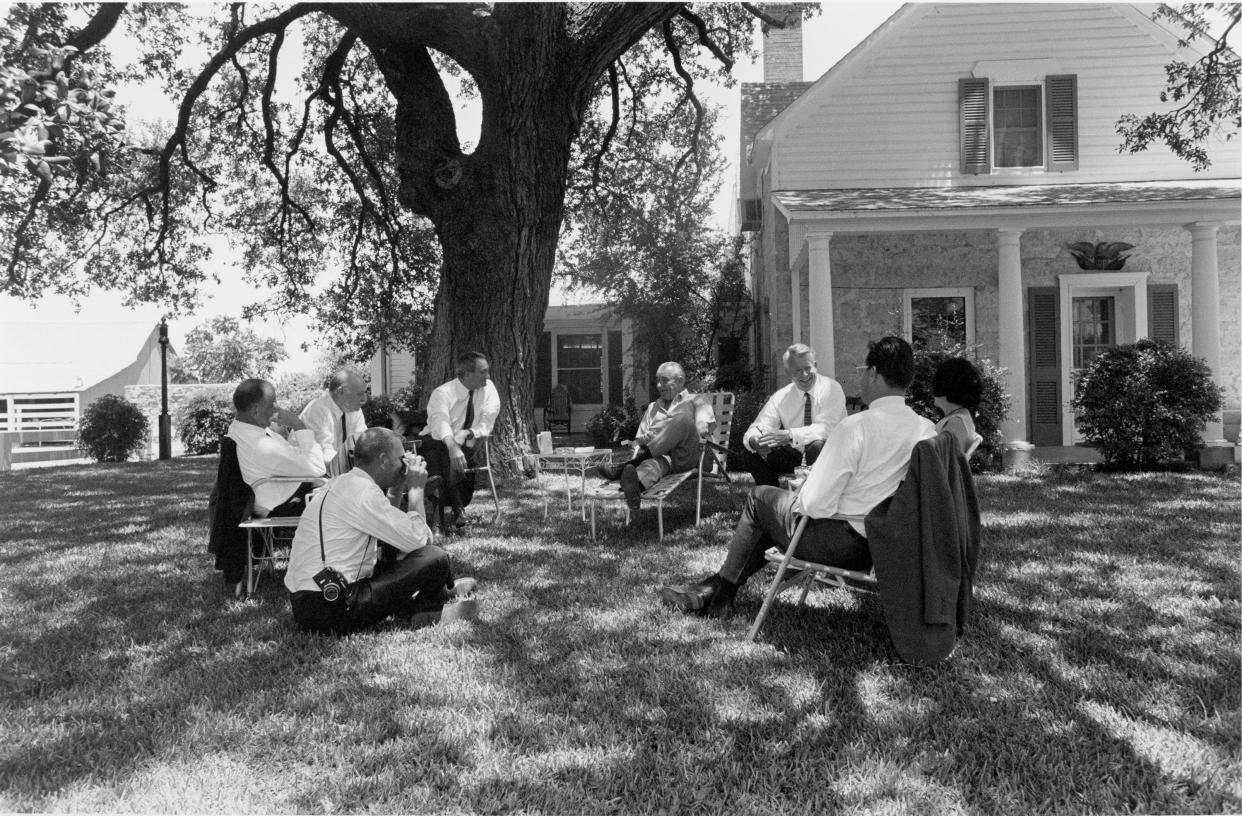 Lyndon B. Johnson and members of the press beneath the Cabinet Oak, on July 8, 1967, at the LBJ Ranch. The tree is estimated to be 300 years old and is still standing at the ranch.