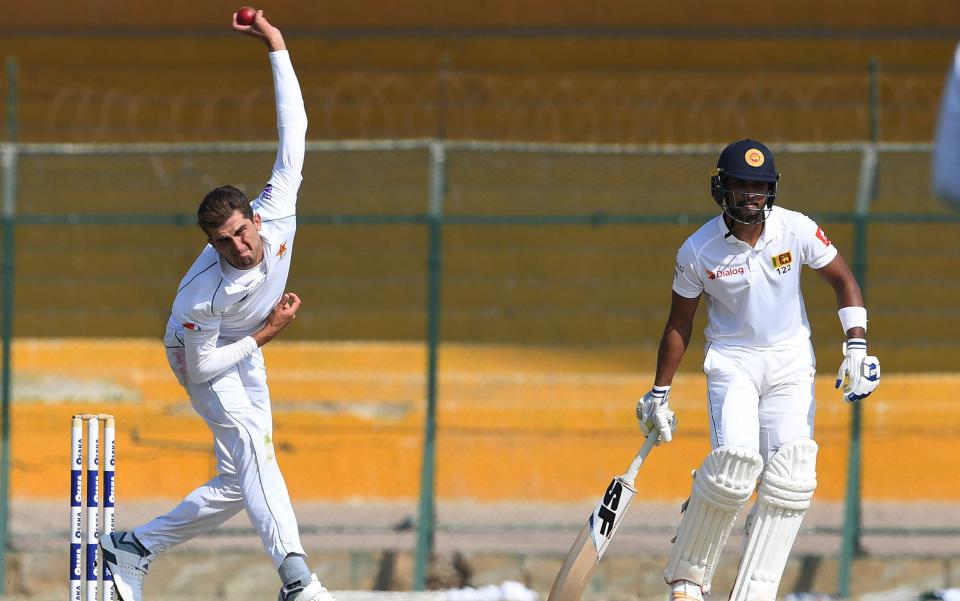 Pakistan's Shaheen Shah Afridi (L) delivers a ball as Sri Lanka's Dinesh Chandimal looks on during the second day of the second Test cricket match between Pakistan and Sri Lanka at the National Cricket Stadium in Karachi on December 20, 2019. - AFP