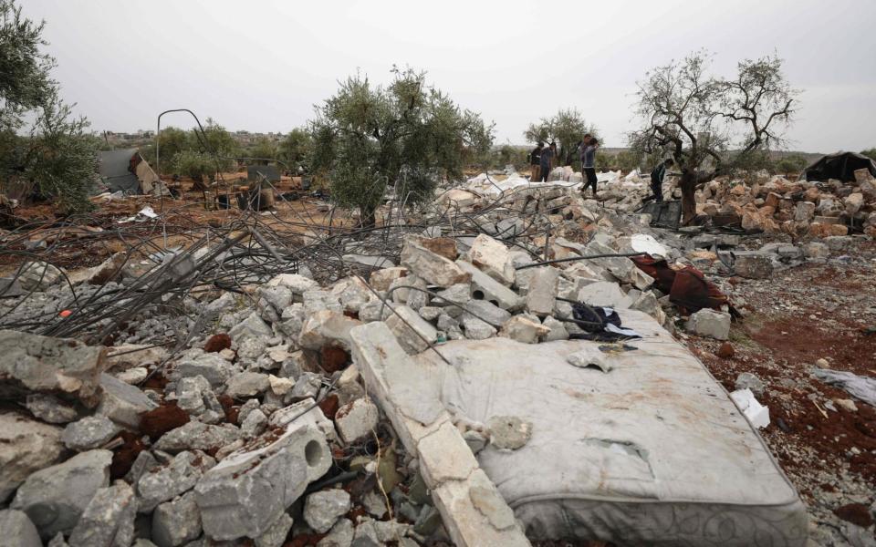 Syrians sift through the rubble at the site of the US-led operation against Islamic State chief Abu Bakr al-Baghdadi - AFP