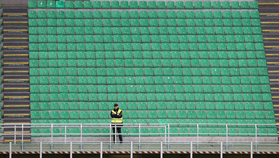 A steward looks on from an empty stand during the Serie A match between AC Milan and Genoa CFC which is being played in a closed stadium at Stadio Giuseppe Meazza on March 8, 2020 in Milan, Italy. (Photo by Marco Luzzani/Getty Images)