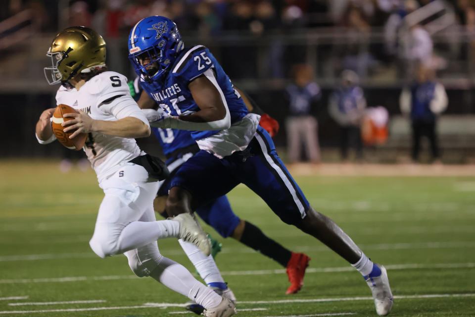 Middletown defensive lineman Tomiwa Durojaiye (25) chases Salesianum quarterback Conor Campbell (14).