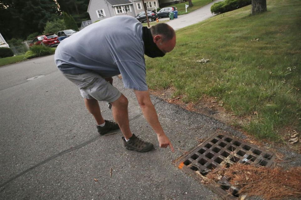 Chris Gagnon, field operations manager for the East Middlesex Mosquito Control Project, points out a paint marker to identify that a storm drain has been treated for mosquito control on Wednesday, July 8, 2020, prior to driving through a neighborhood in Burlington, Mass. Officials are preparing for another summer with a high number of cases of eastern equine encephalitis, a rare but severe neurological illness transmitted by mosquitoes that hit the state particularly hard last summer. (AP Photo/Charles Krupa)