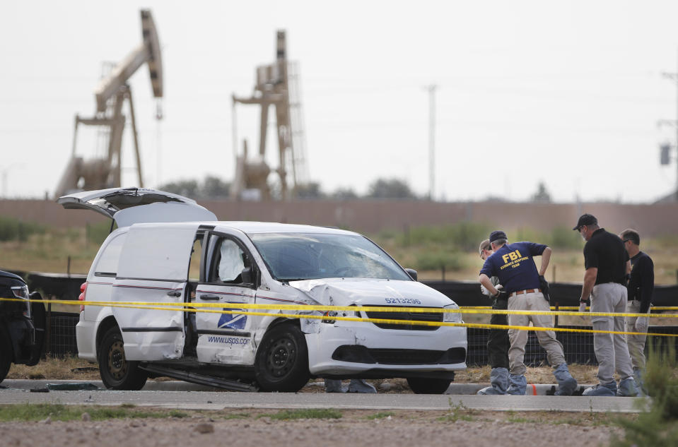 Authorities look at a U.S. Mail vehicle, which was involved in Saturday's shooting, outside the Cinergy entertainment center Sunday, Sept. 1, 2019, in Odessa, Texas. (Mark Rogers/Odessa American via AP)