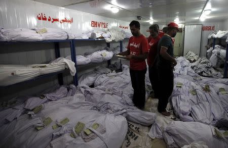 Volunteers search for the bodies of deceased among people who died due to an intense heat wave, at Edhi Foundation morgue in Karachi, Pakistan, June 22, 2015. REUTERS/Akhtar Soomro