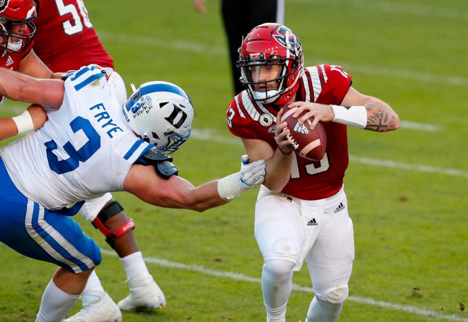 N.C. State quarterback Devin Leary (13) avoids the pressure by Duke’s Ben Frye during the second half of N.C. State’s 31-20 victory over Duke at Carter-Finley Stadium in Raleigh, N.C., Saturday, Oct. 17, 2020.