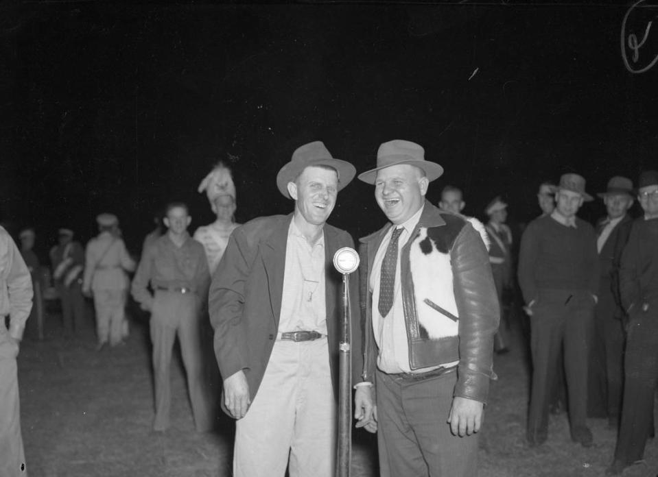 1941: Singers at the Electra, Texas Chuck Wagon Feed are Clifford Gage, left, and W. L. Gassity, Electra, Texas. The men are standing in front of a microphone. The dinner is sponsored by the oil bureau of the Electra Chamber of Commerce. 