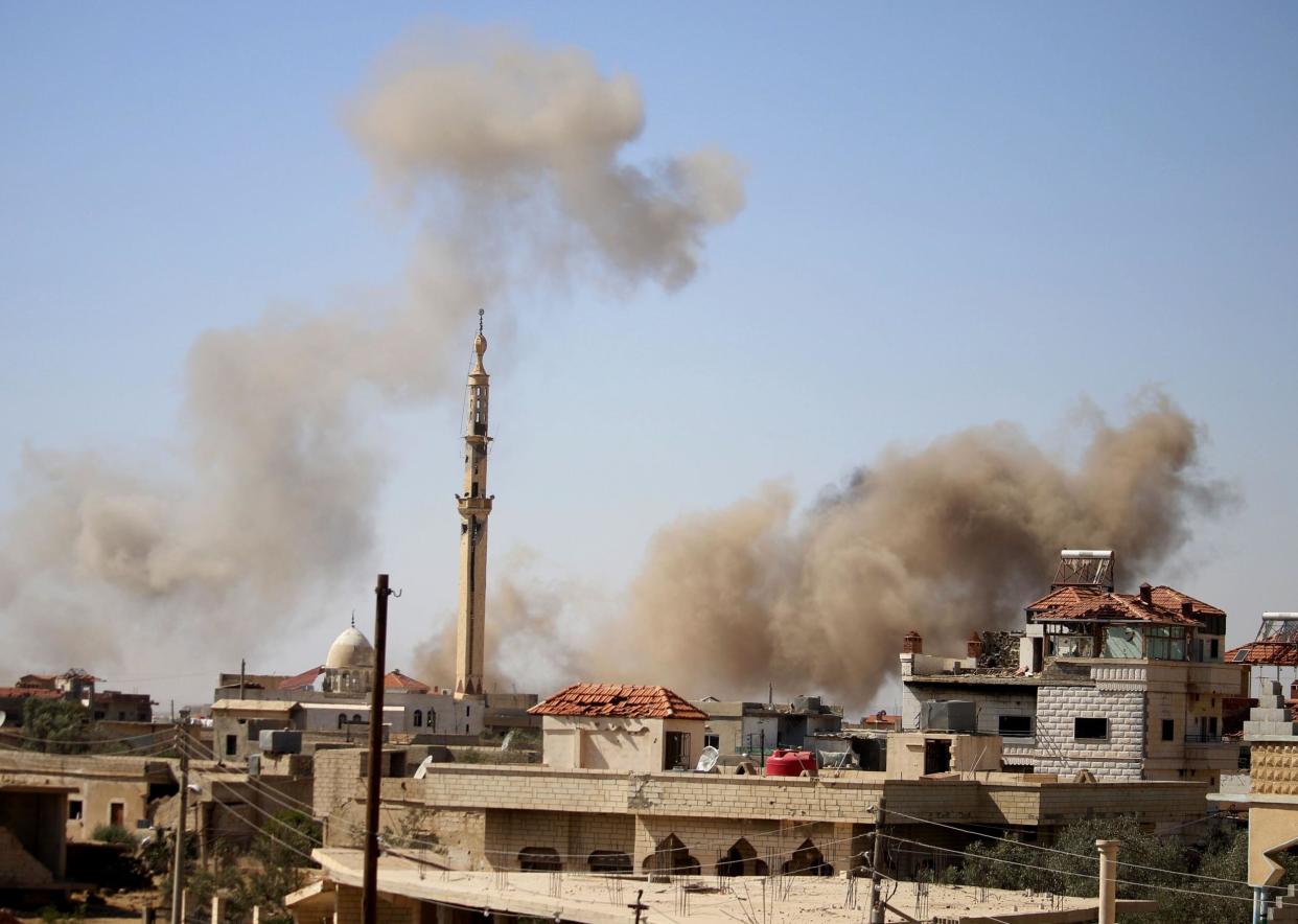 Smoke rises above buildings during an airstrike by Syrian regime forces on the town of Busra al-Harir, east of Daraa: AFP/Getty