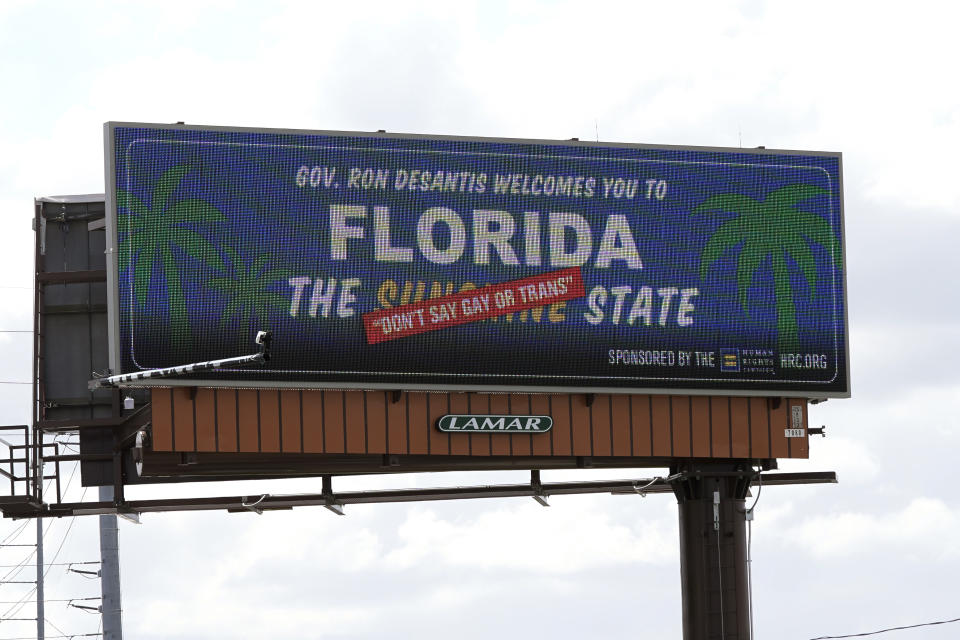 FILE - A new billboard welcoming visitors to "Florida: The Sunshine 'Don't Say Gay or Trans' State," is seen on April 21, 2022, in Orlando, Fla. Florida's state government and LGBTQ+ advocates have settled a lawsuit challenging a law that bars teaching about sexual orientation and gender identity in public schools. (AP Photo/John Raoux, File)