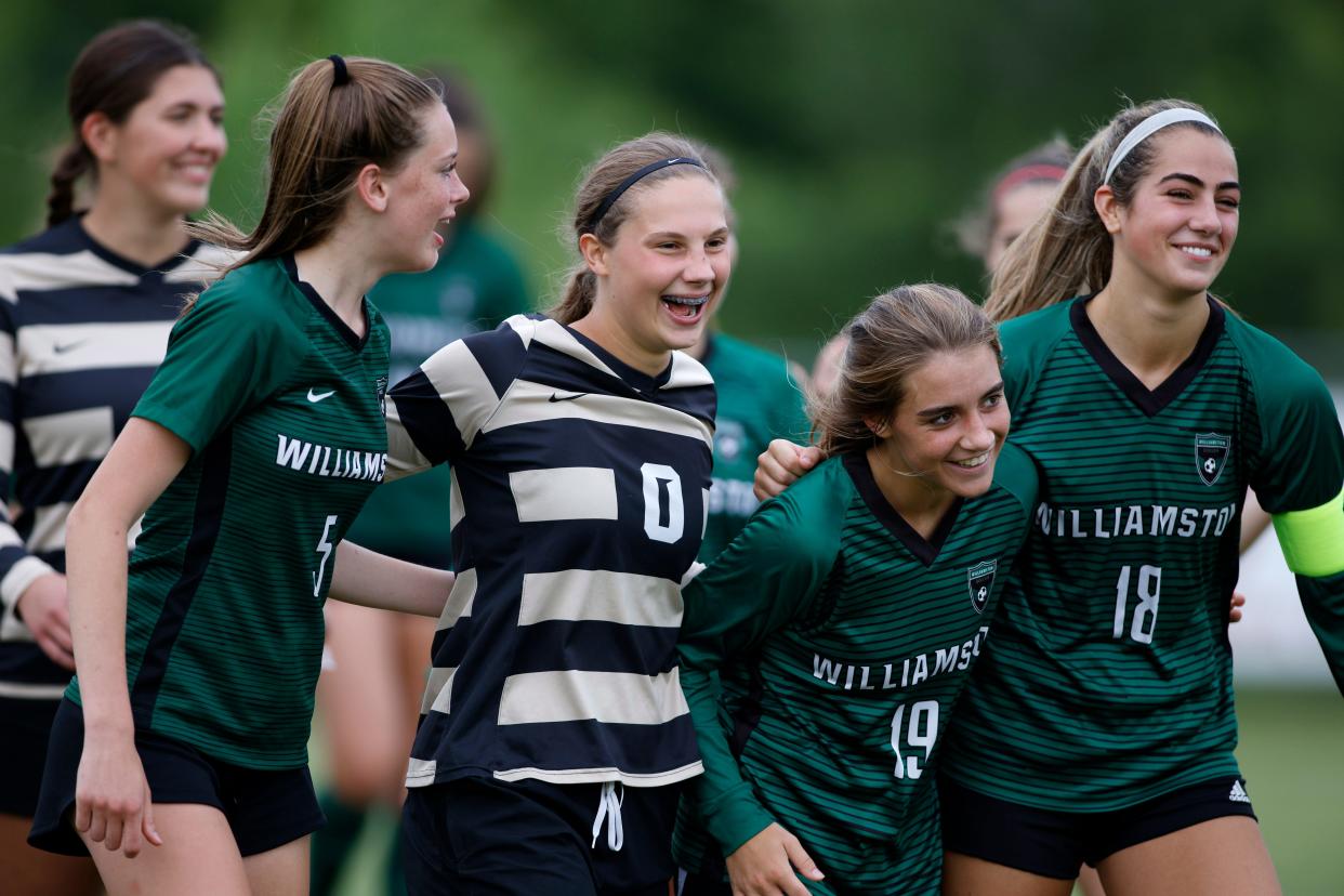 Williamston's Ella Kleiver (L-R), Abby Pieper, Liz Bellinger and Ellie Maxson celebrate the Hornets' 4-0 win over Flint Powers Catholic on Saturday, June 11, 2022, in Williamston.