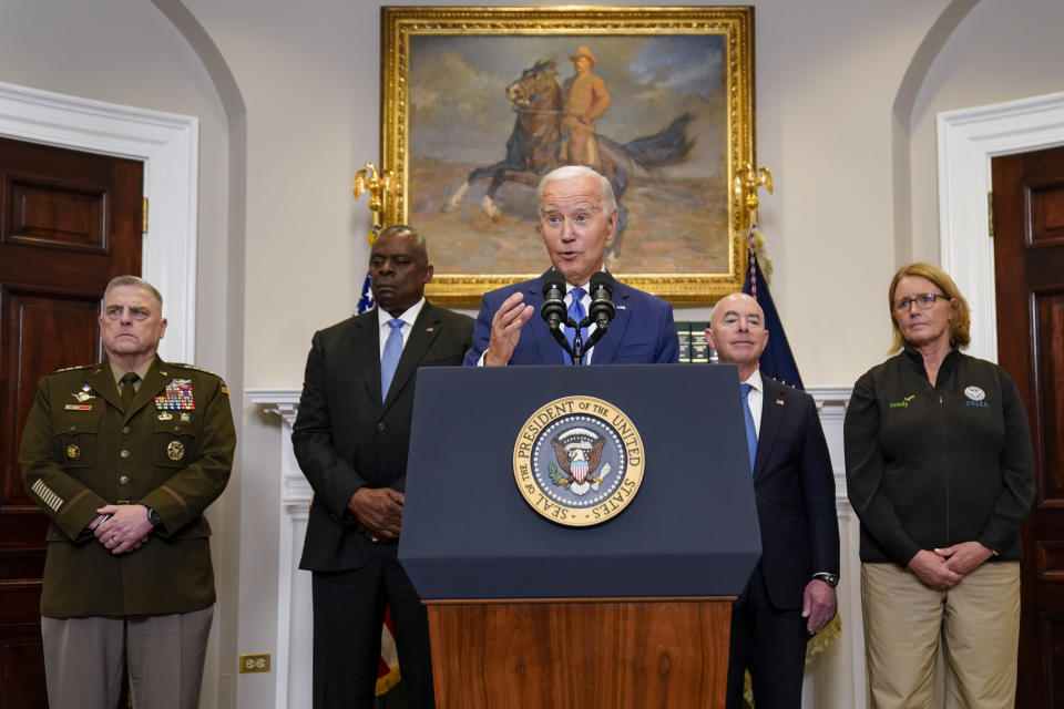 President Joe Biden, center, delivers remarks on recovery efforts for the Maui wildfires and the response to Hurricane Idalia, in the Roosevelt Room of the White House, Wednesday, Aug. 30, 2023, in Washington. Joint Chiefs Chairman Gen. Mark Milley, left, Secretary of Defense Lloyd Austin, Homeland Security Secretary Alejandro Mayorkas, and Federal Emergency Management Agency administrator Deanne Criswell stand behind Biden. (AP Photo/Evan Vucci)