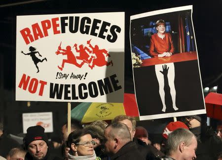 Members of LEGIDA, the Leipzig arm of the anti-Islam movement Patriotic Europeans Against the Islamisation of the West (PEGIDA), hold a placard showing German Chancellor Angela Merkel (R) as they take part in a rally in Leipzig, Germany, January 11, 2016. REUTERS/Fabrizio Bensch