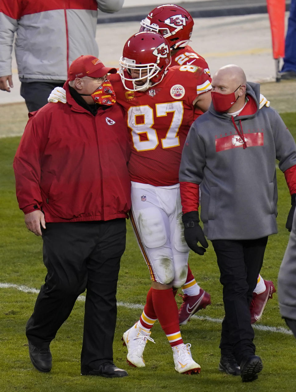 FILE - In this Jan. 17, 2021, file photo, Kansas City Chiefs tight end Travis Kelce (87) walks off the field with coach Andy Reid after an NFL divisional round football game against the Cleveland Browns in Kansas City, Mo. Both Reid and Bruce Arians are considered players’ coaches, though they do it in different ways. It's a quality that’s helped them reach the Super Bowl. (AP Photo/Orlin Wagner, File)