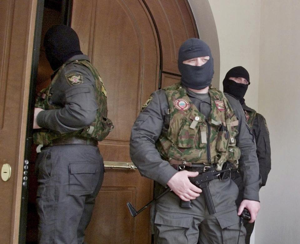 FILE - Masked and armed police officers stand outside the central office of Media-Most holding company in Moscow, May 11, 2000. Tax police raided the offices of Media-Most's subsidiary, NTV, a popular independent broadcaster noted for critical coverage of the Kremlin. It was the first salvo in moves against prominent independent media that have characterized the Putin era. (AP Photo/Misha Japaridze, File)