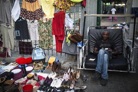 An African migrant, working as a street vendor, waits for customers in south Tel Aviv July 17, 2013. REUTERS/Amir Cohen