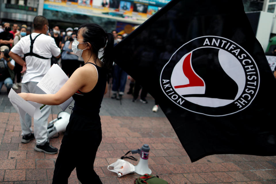 A demonstrator wearing a mask holds an ''Antifaschistische Aktion'' flag during a protest march over the alleged police abuse of a Turkish man, in echoes of a Black Lives Matter protest, following the death of George Floyd who died in police custody in Minneapolis, in Tokyo, Japan June 6, 2020.   REUTERS/Issei Kato