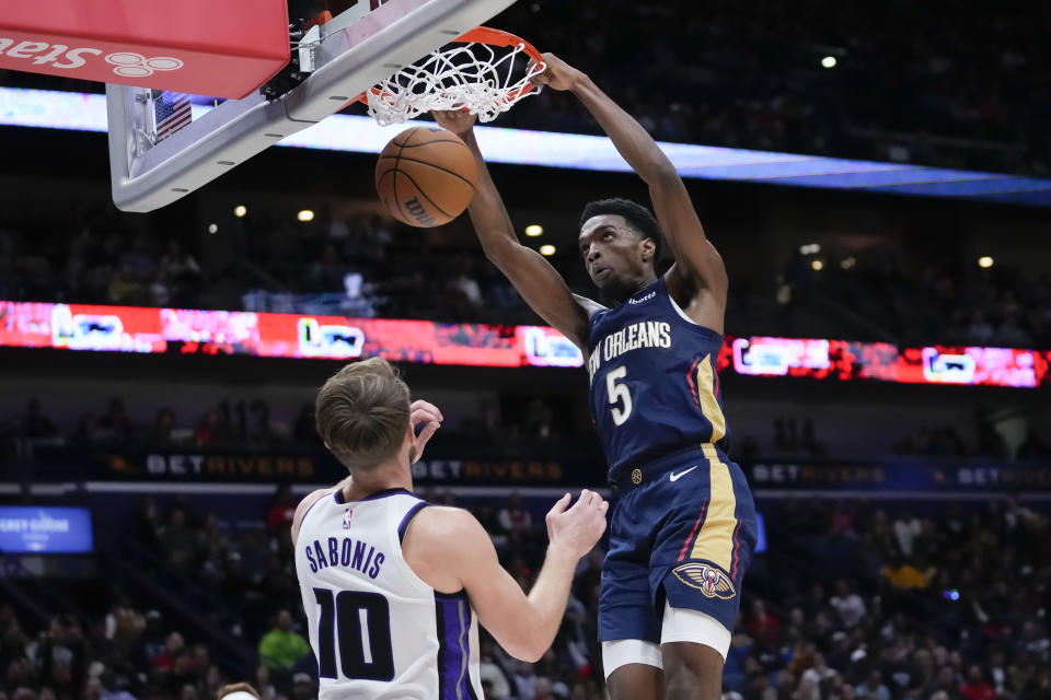 New Orleans Pelicans forward Herbert Jones (5) slam dunks over Sacramento Kings forward Domantas Sabonis (10) in the first half of an NBA basketball game in New Orleans, Wednesday, Nov. 22, 2023. (AP Photo/Gerald Herbert)