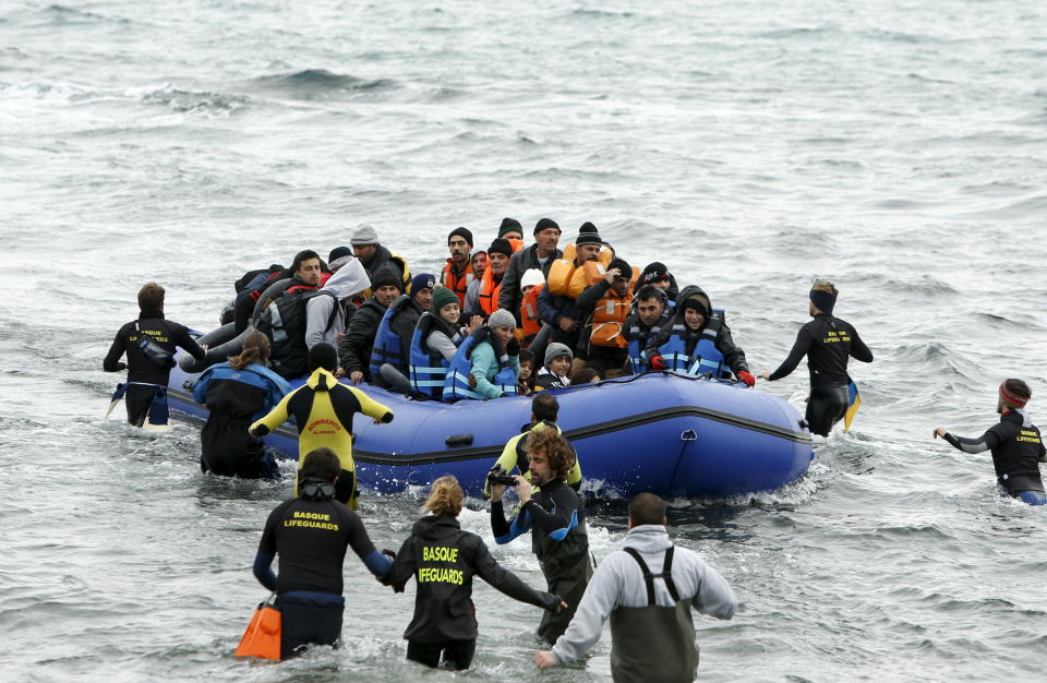Volunteers approach a rubber dinghy packed with migrants and refugees as it arrives on Lesbos on Jan. 29, 2016.