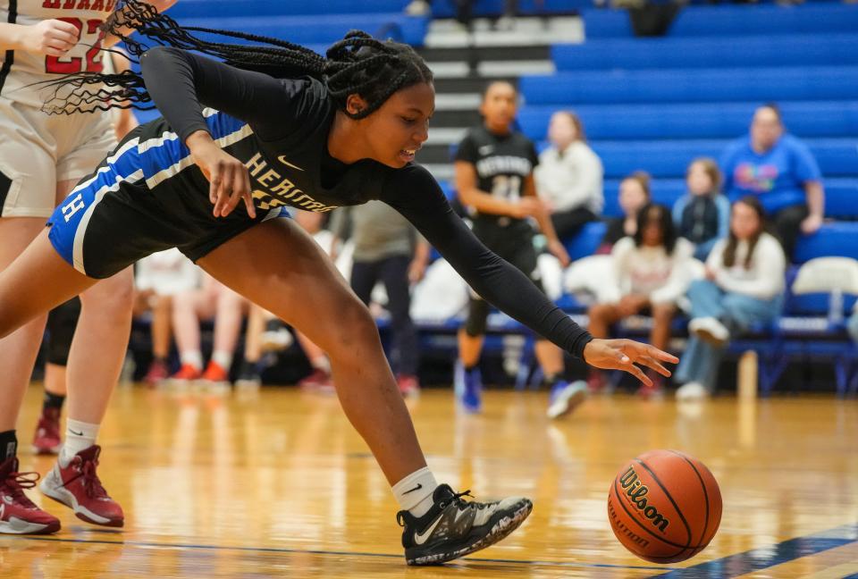 Heritage Christian Eagles forward Trinity Taylor (11) reaches for the ball as it rolls out of bounds Tuesday, Jan. 30, 2024, during the game at Bishop Chatard High School in Indianapolis.