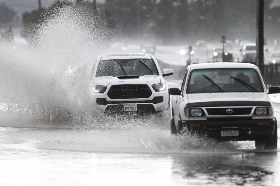 Trucks drive down a flooded street, Tuesday, Feb. 6, 2024, in Lakeside, Calif. The National Weather Service issued a tornado warning for parts of East San Diego county including Lakeside. (AP Photo/Denis Poroy)