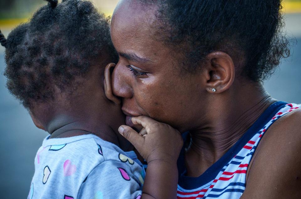 Akiela Atkinson kisses her daughter, Ajhonaiste Rivers, 1, as she cries Monday, Aug. 29, 2022, in frustration over being without a home. As the two stand outside their hotel on Indianapolis' west side, Atkinson notices her car is gone from the parking lot. "He must have gone to give plasma," she said of her child's father, Johnny Rivers. The two are struggling daily to find the money needed to stay in their hotel room.