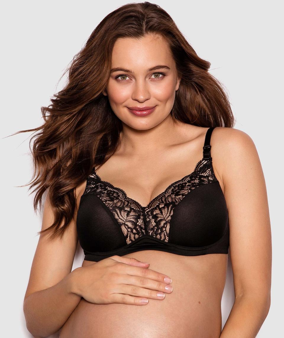 A dark-haired pregnant woman wears a lacy maternity bra.