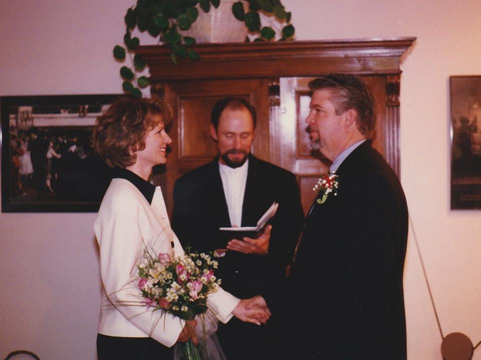 a bride and groom getting married in their living room with a minister