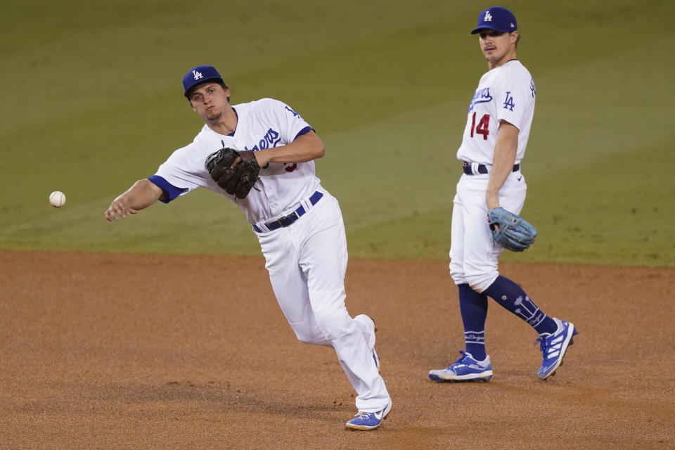 Los Angeles Dodgers shortstop Corey Seager throws to first to put out Los Angeles Angels' Albert Pujols during the fifth inning of a baseball game Friday, Sept. 25, 2020, in Los Angeles. Second baseman Enrique Hernandez is at right. (AP Photo/Ashley Landis)