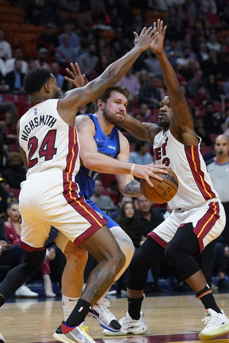 Dallas Mavericks guard Luka Doncic, center, attempts a shot against Miami Heat forwards Haywood Highsmith (24) and Jimmy Butler during the first half of an NBA basketball game, Tuesday, Feb. 15, 2022, in Miami. (AP Photo/Wilfredo Lee)