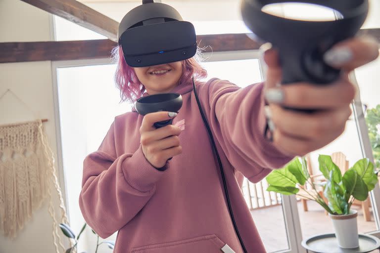 Una joven con un visor de realidad virtual de Oculus, una firma tecnológica que forma parte de Meta, la compañía liderada por Mark Zuckerberg que apuesta fuerte a los desarrollos de realidad aumentada y mixta