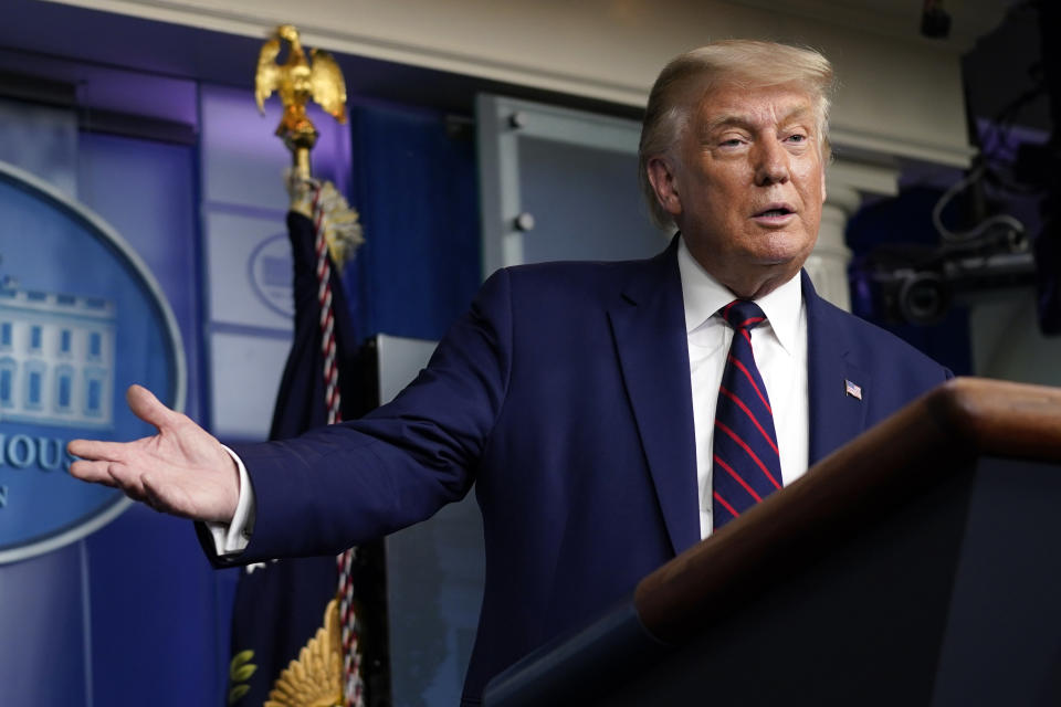 President Donald Trump gestures for Larry Kudlow, White House chief economic adviser, to speak during a news conference in the James Brady Press Briefing Room at the White House, Friday, Sept. 4, 2020, in Washington. (AP Photo/Evan Vucci)