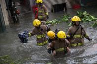 <p>Rescuers carry a woman across a flooded street during Typhoon Mangkhut in Lei Yu Mun, Hong Kong, China, on Sept. 16, 2018.<br>The No 10 typhoon warning was raised in the early hours as Typhoon Mangkhut sweeps past Hong Kong.<br>(Photo by Jerome Favre, EPA) </p>