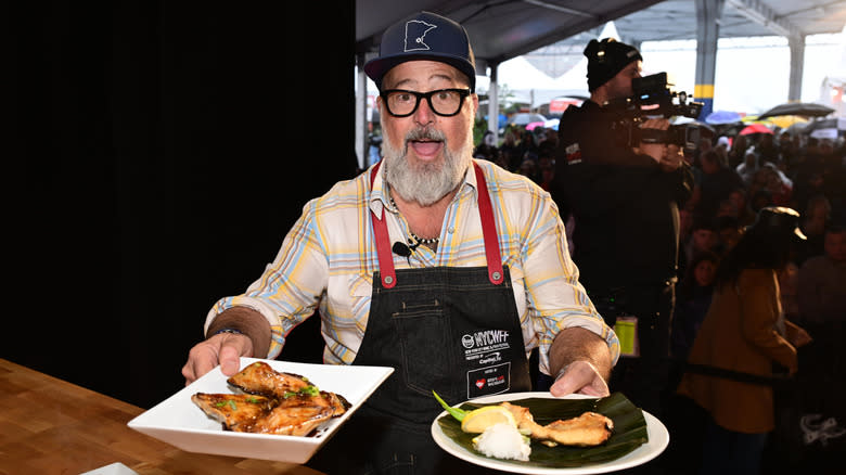 Andrew Zimmern holding plates