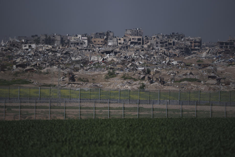 Bombed-out buildings on the eastern edge of Gaza City are visible across the double fence that separates the Strip from Kibbutz Nahal Oz, Israel, Wednesday, Feb. 7, 2024. (AP Photo/Leo Correa)