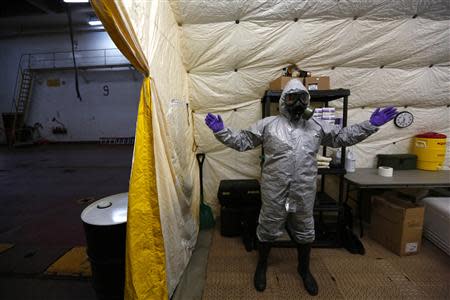 A U.S. MV Cape Ray ship staff member wearing personal protective equipment is seen at the naval airbase in Rota, near Cadiz, southern Spain April 10, 2014. REUTERS/Marcelo del Pozo