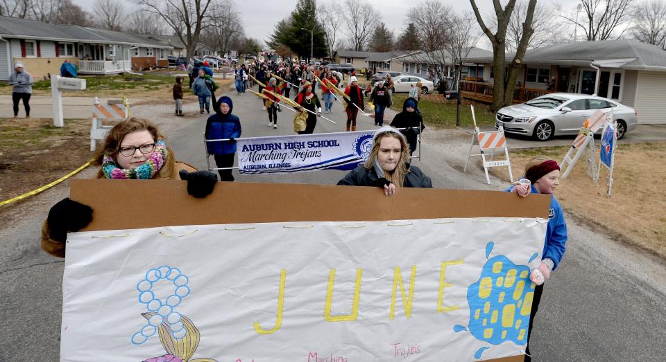 A parade makes its way down East Washington Street in Auburn past June Peden-Stade's home on Saturday.