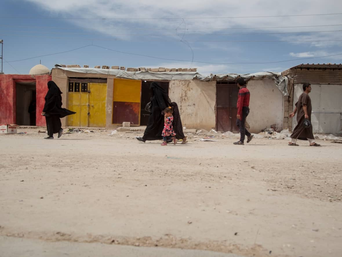 People walk in the marketplace at the al-Hol camp that houses some 60,000 refugees, including families and supporters of the Islamic State group, in Hasakeh province, Syria, on May 1, 2021. (Baderkhan Ahmad/The Associated Press - image credit)