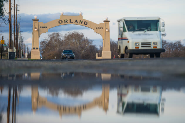 A U.S. Postal Service delivery vehicle after passing through the iconic Orland Arch in Orland, Calif. Amazon’s last mile delivery buildout will reduce the company’s dependence on the USPS and United Parcel Service. (Photo by <a href="http://www.chriskaufman.com/" rel="nofollow noopener" target="_blank" data-ylk="slk:Chris Kaufman;elm:context_link;itc:0;sec:content-canvas" class="link ">Chris Kaufman</a> for GeekWire.)