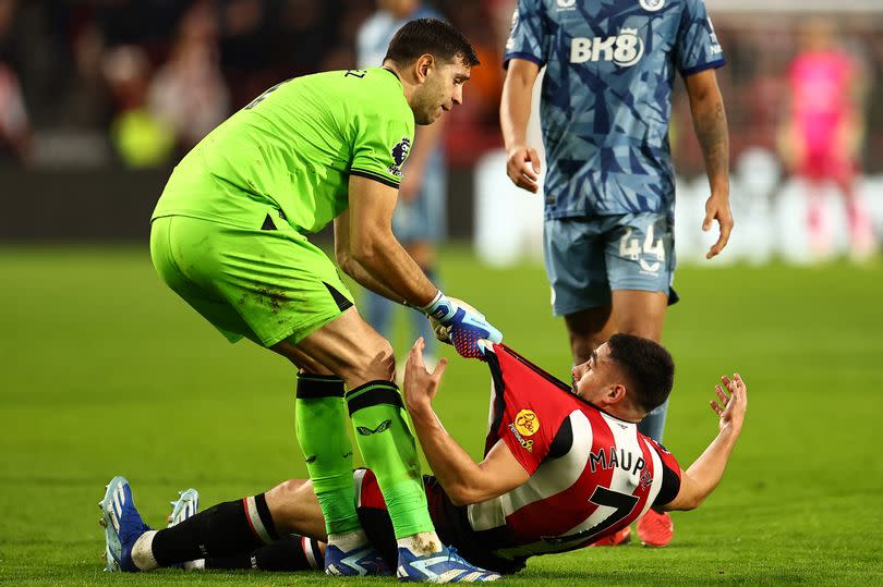 Aston Villa goalkeeper Emiliano Martinez drags Brentford striker Neal Maupay up