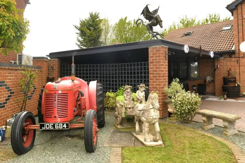 A vintage tractor is among other curiosities in Lee's well-maintained garden