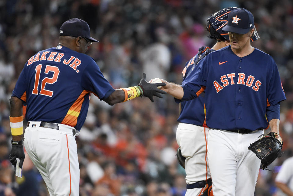 Houston Astros starting pitcher Zack Greinke, right, is removed from the baseball game by manager Dusty Baker Jr. (12) during the seventh inning against the Texas Rangers, Sunday, July 25, 2021, in Houston. (AP Photo/Eric Christian Smith)