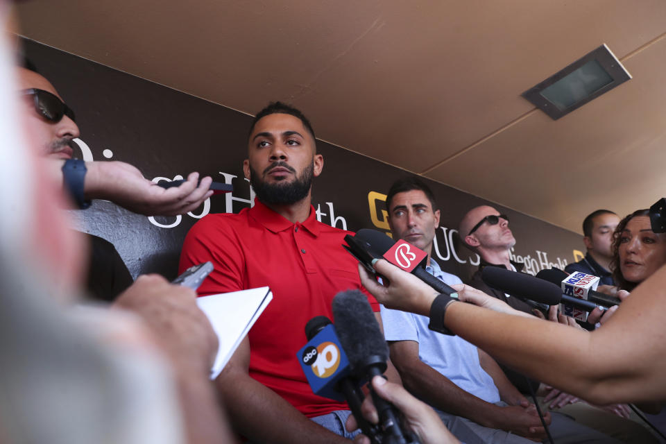San Diego Padres' Fernando Tatis Jr., center, speaks to the media about his 80 game suspension from baseball after testing positive for Clostebol, a performance-enhancing substance in violation of Major League Baseball's Joint Drug Prevention and Treatment Program, Tuesday, Aug. 23, 2022, in San Diego. (AP Photo/Derrick Tuskan)