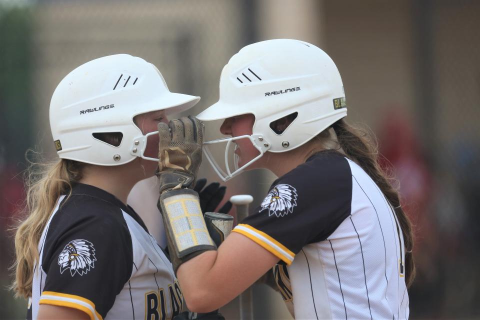 Cowan softball's McKenna Minton (right) hypes up her teammate in the team's IHSAA semistate first-round game at Frankfort High School on Saturday, June 3, 2023.