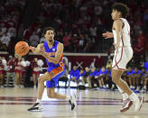 Florida guard Myreon Jones, left, passes the ball past Oklahoma forward Jalen Hill during the first half of an NCAA college basketball game in Norman, Okla., Wednesday, Dec. 1, 2021. (AP Photo/Kyle Phillips)