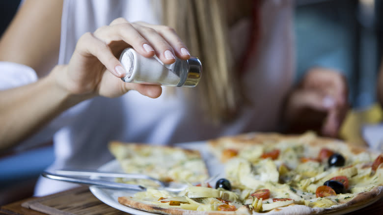 Woman salting her food