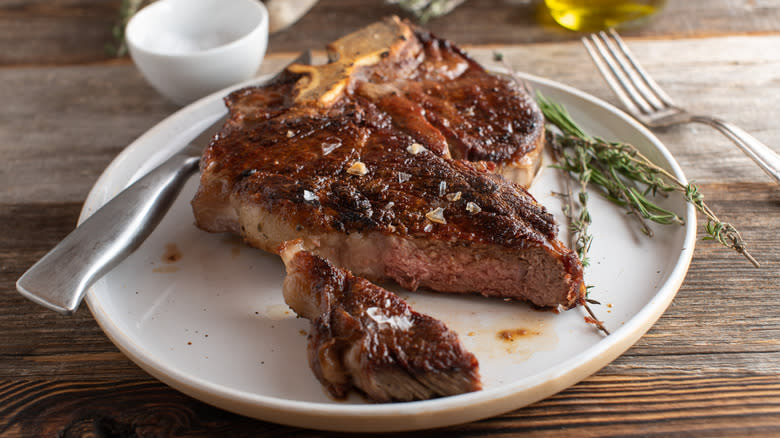 Dry aged steak cooked on plate with herbs