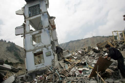 A Chinese rescuer in May 2008 checks a collapsed building for earthquake survivors in Wenchuan, in southwest China's Sichuan province