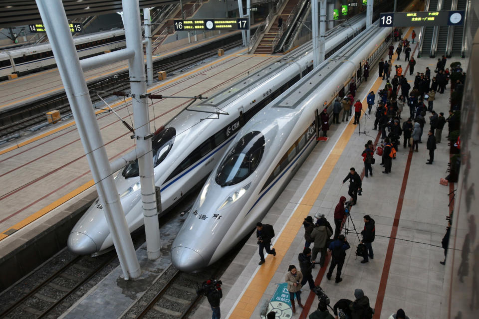 Journalists gathers beside the high speed train of the new 2,298-kilometre (1,425-mile) line between Beijing and Guangzhou as it waits to start off in Beijing on December 26, 2012. China started service on December 26 on the world's longest high-speed rail route, the latest milestone in the country's rapid and -- sometimes troubled -- super fast rail network. The opening of this new line means passengers will be whisked from the capital to the southern commercial hub in just eight hours, compared with the 22 hours previously required. CHINA OUT AFP PHOTO