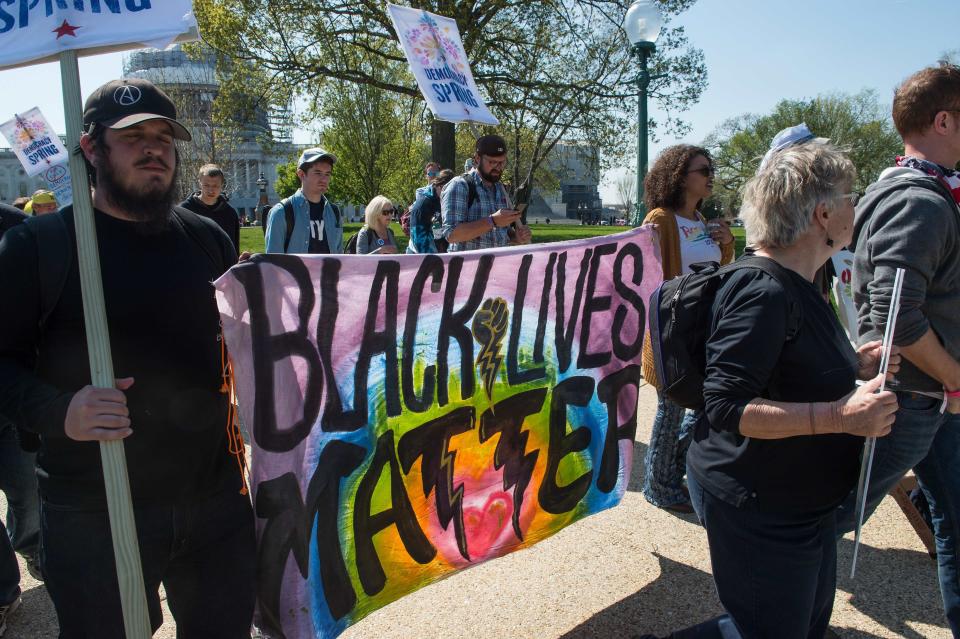 Activists of the grassroots Democracy Spring movement carry signs during a march near the Capitol on April 14, 2016.