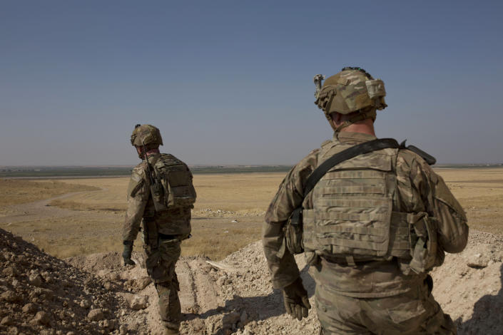 FILE - In this Sept. 6, 2019, file photo, U.S. soldiers survey the the safe zone between Syria and the Turkish border near Tal Abyad, Syria, on a joint patrol with the Tax Abyad Military Council, affiliated with the U.S.-backed Syrian Democratic Forces. When dozens of heads of state convene for the annual ministerial meeting of the U.N. General Assembly, the lingering conflict in Syria is taking a back seat as tensions in the Persian Gulf and global trade wars take center stage. In its ninth year, many Syrians fear their country’s unresolved war has become a footnote in a long list of world crises. (AP Photo/Maya Alleruzzo, File)