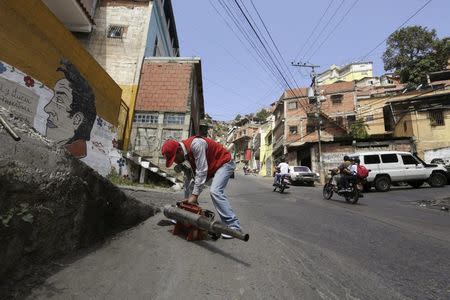 A health worker starts a fumigation machine before fumigating the Valley slum to help control the spread of the mosquito-borne Zika virus in Caracas, January 28, 2016. REUTERS/Marco Bello